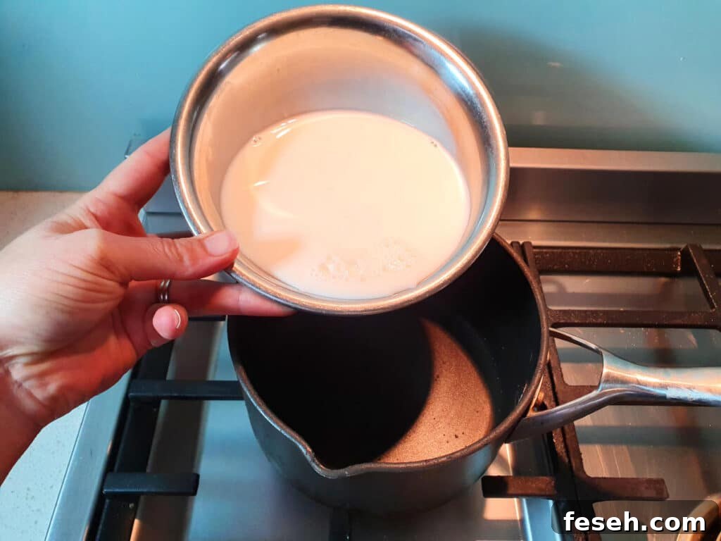 adding milk to pot on stove.