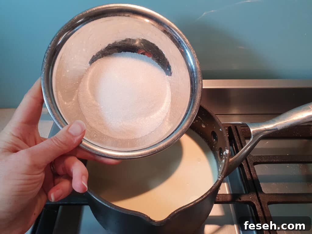 adding sugar to ice cream mix in pot on stove.