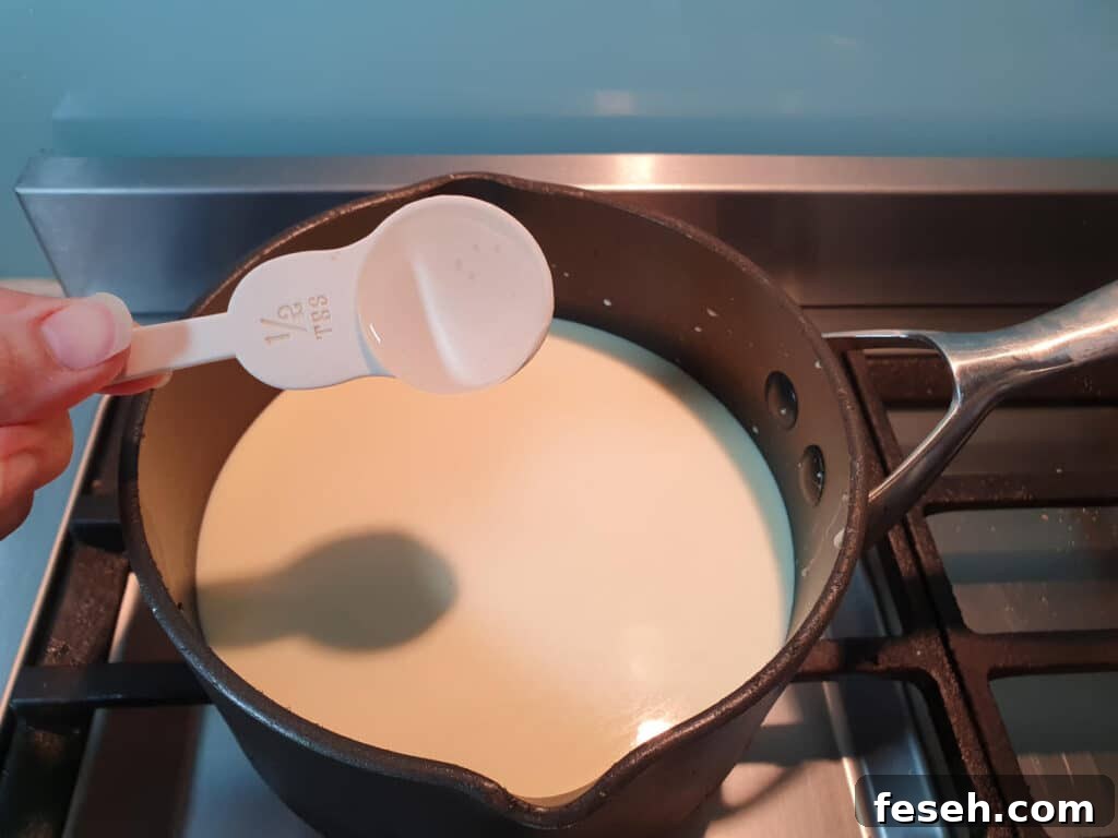adding glycose syrup to ice cream mix in pot on stove.