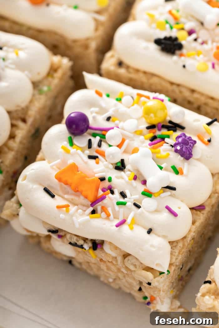 Close up of frosting halloween rice krispie treats topped with halloween sprinkles