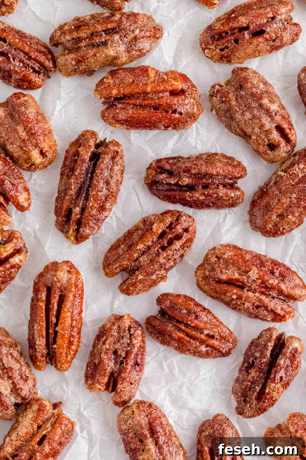 baked candied pecans on a piece of white parchment paper