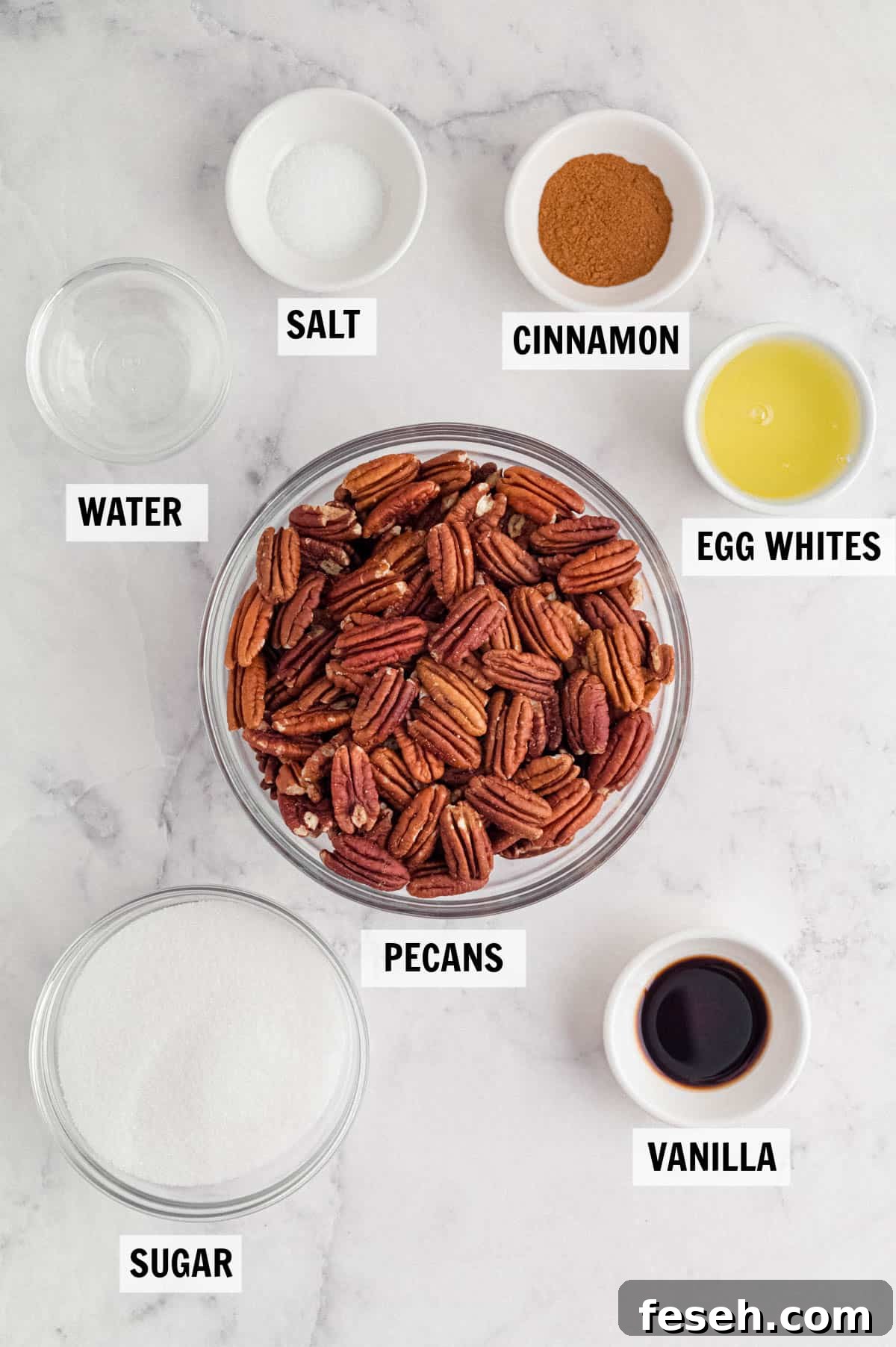 all of the ingredients for the candied pecans on a white countertop