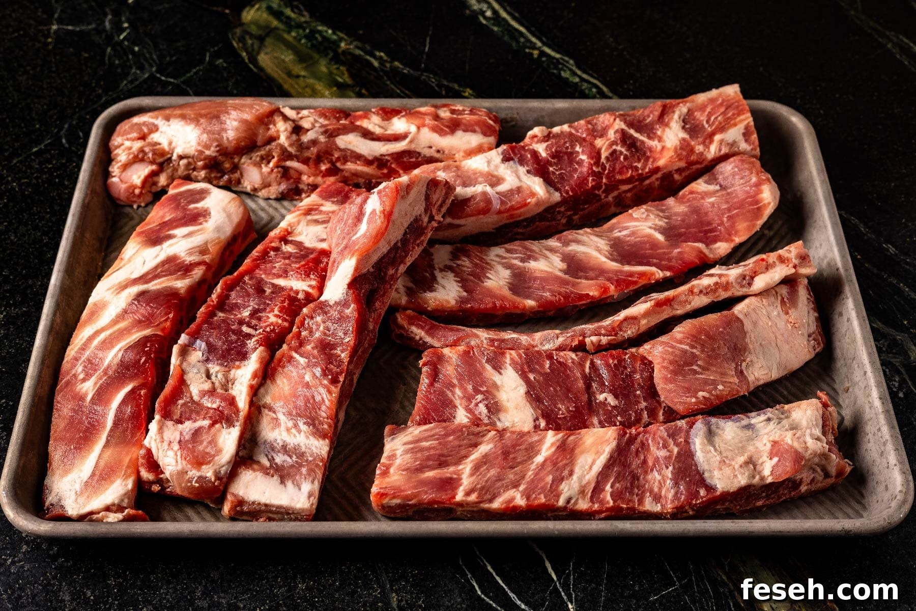 Uncooked ribs on baking sheet.