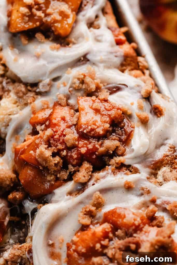 A close-up of the topped peach cinnamon rolls in the pan.