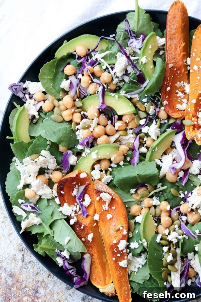 colorful superfood spinach salad on plate garnished with roasted squash