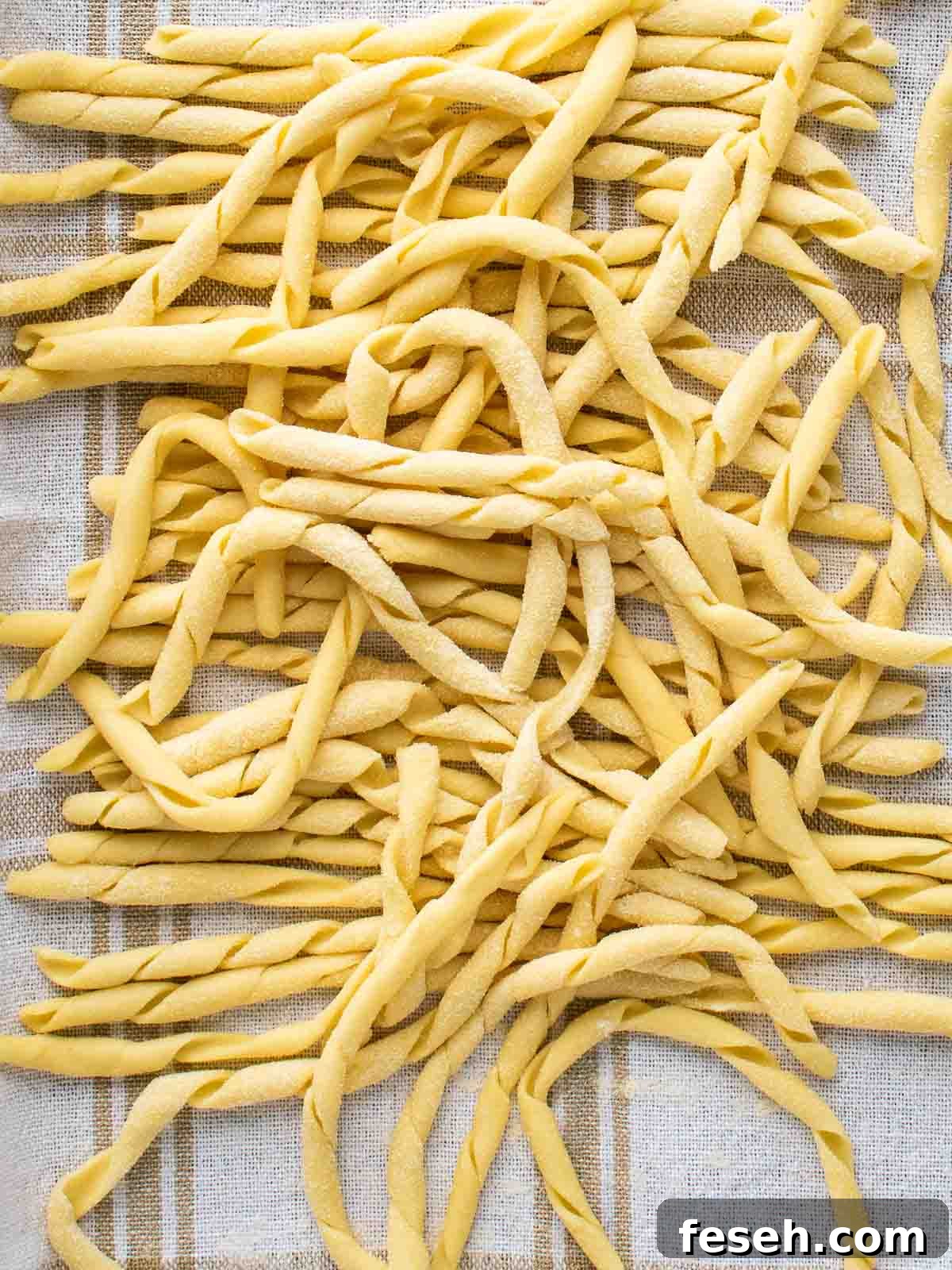Busiate pasta on a kitchen towel viewed from above.
