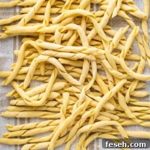 Busiate pasta on a kitchen towel viewed from above.