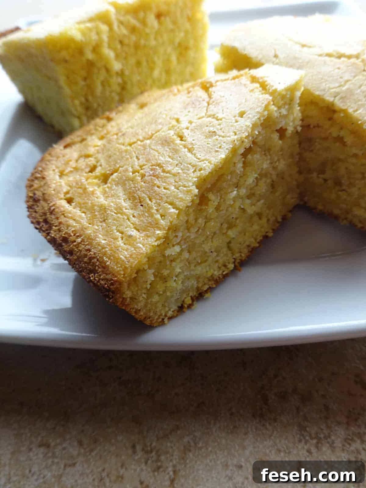 Pieces of cooked cornbread on plate ready to eat.