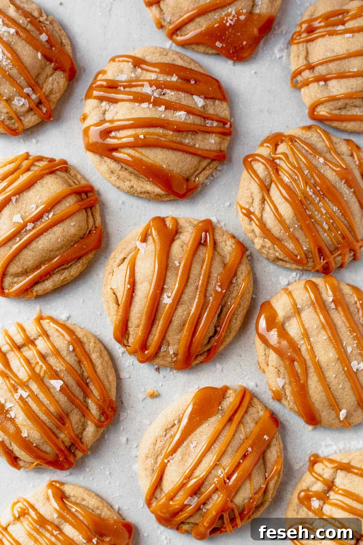 caramel cheesecake cookies with caramel topping cooling on parchment paper