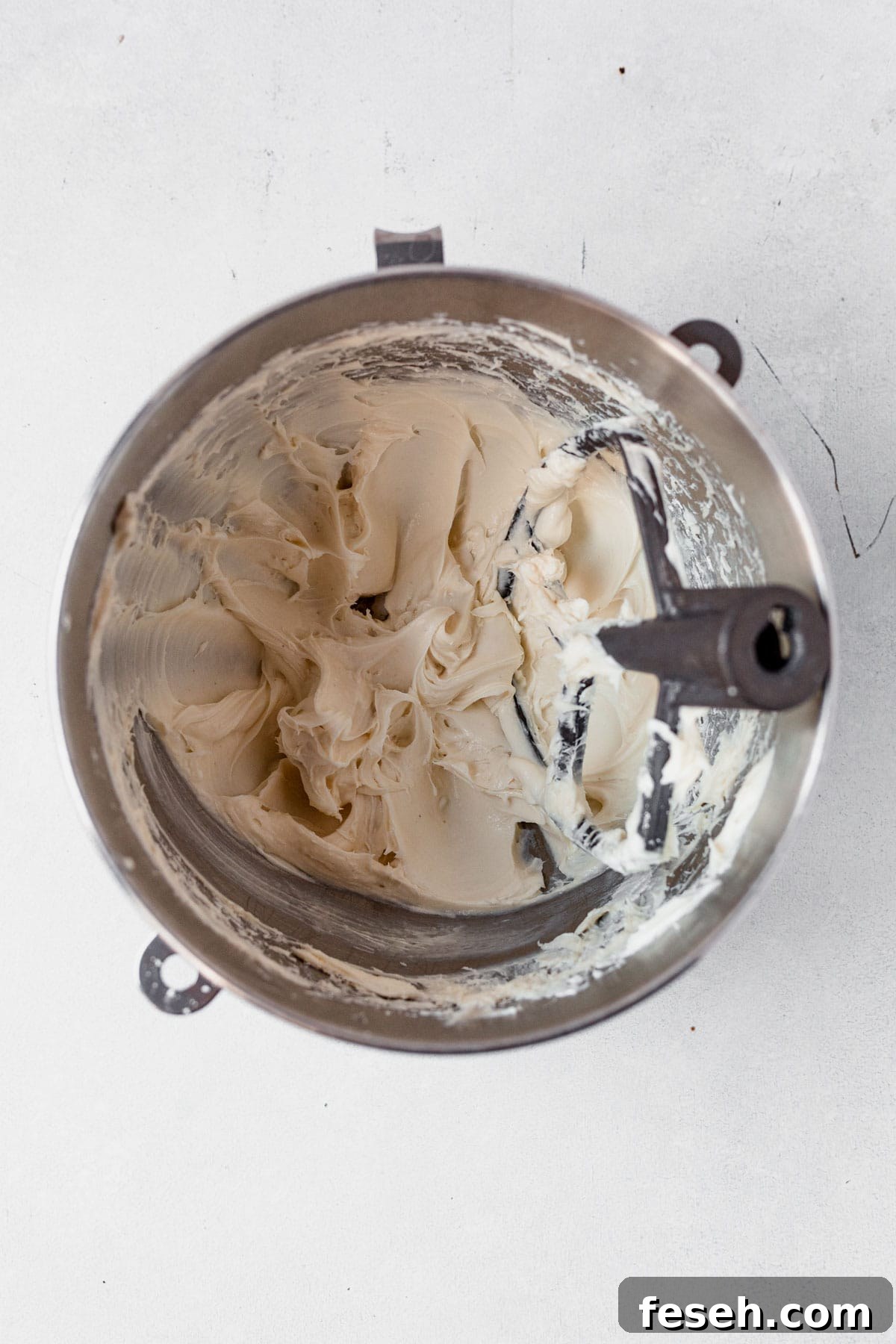 frosting for caramel cheesecake cookies mixed in a bowl with the paddle attachment.