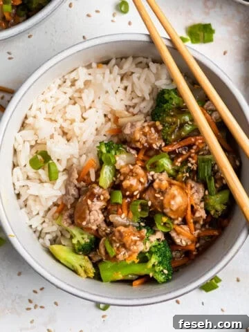 Teriyaki ground pork stir fry in bowl with white rice and chopsticks.