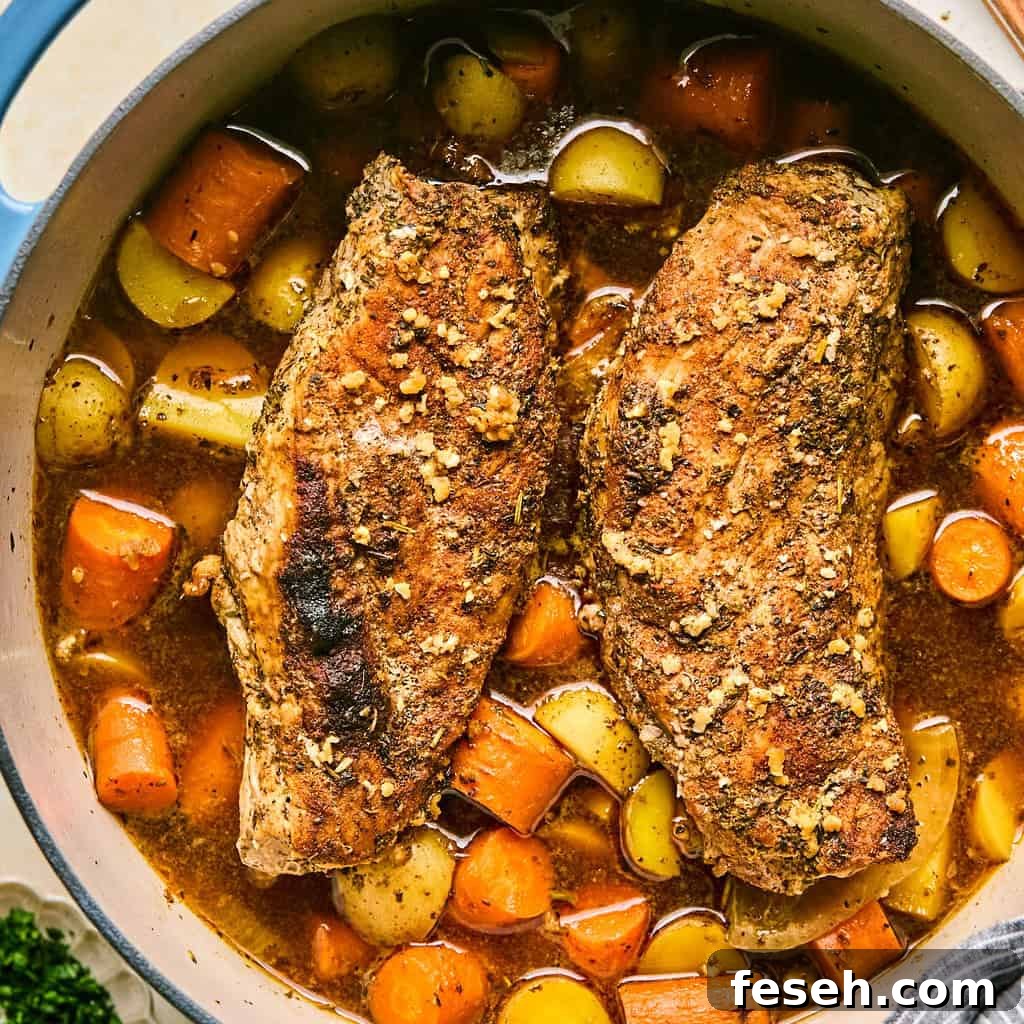 Dutch oven with roasted pork tenderloin, carrots and potatoes.