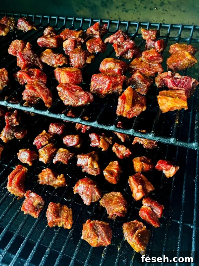 cubes of steak on smoker before cooking