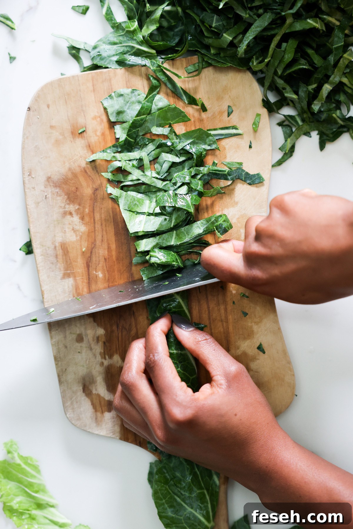 Thinly slicing collard greens in chiffonade style.