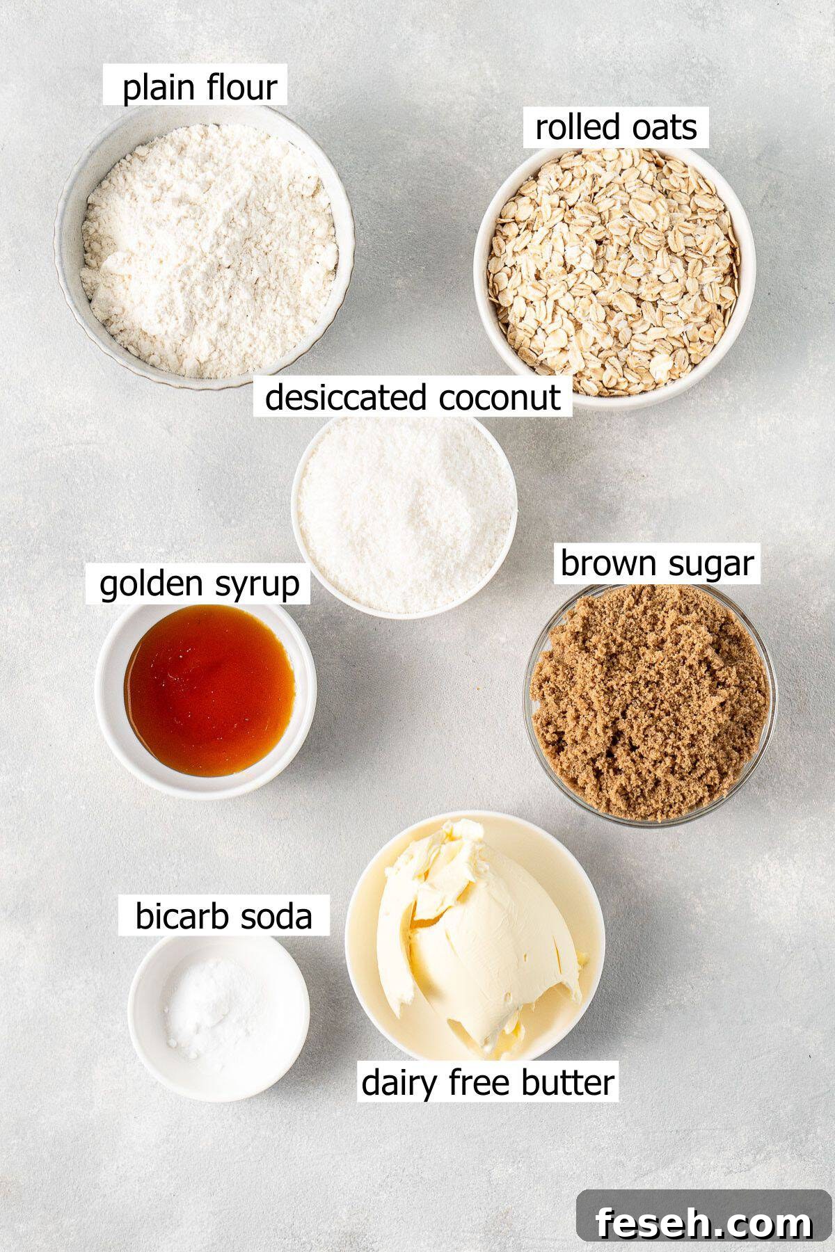 All ingredients needed to make ANZAC biscuits laid out in small bowls.