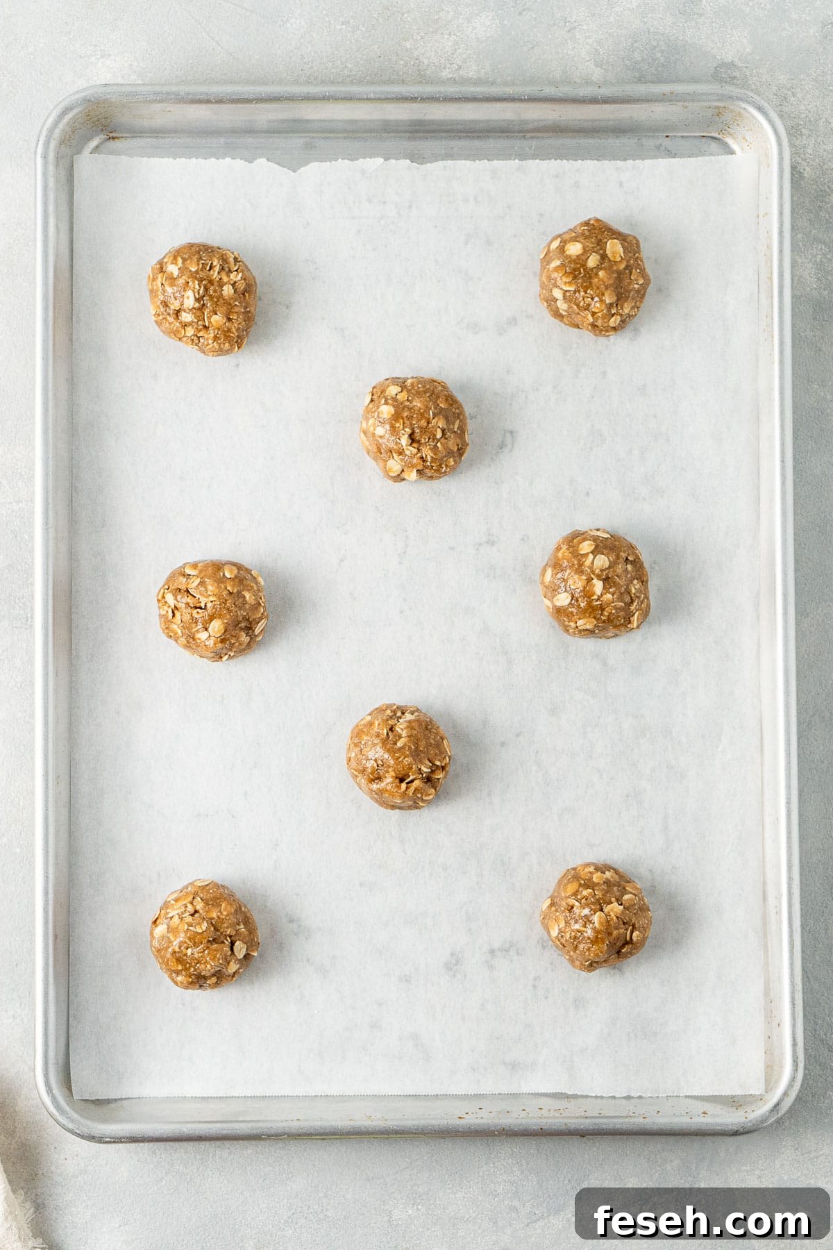 The biscuit dough rolled into balls and placed on a baking tray.