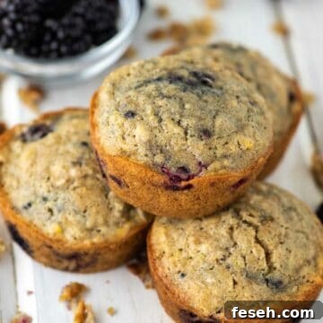 close-up of blackberry oatmeal muffin stacked on top of 3 others
