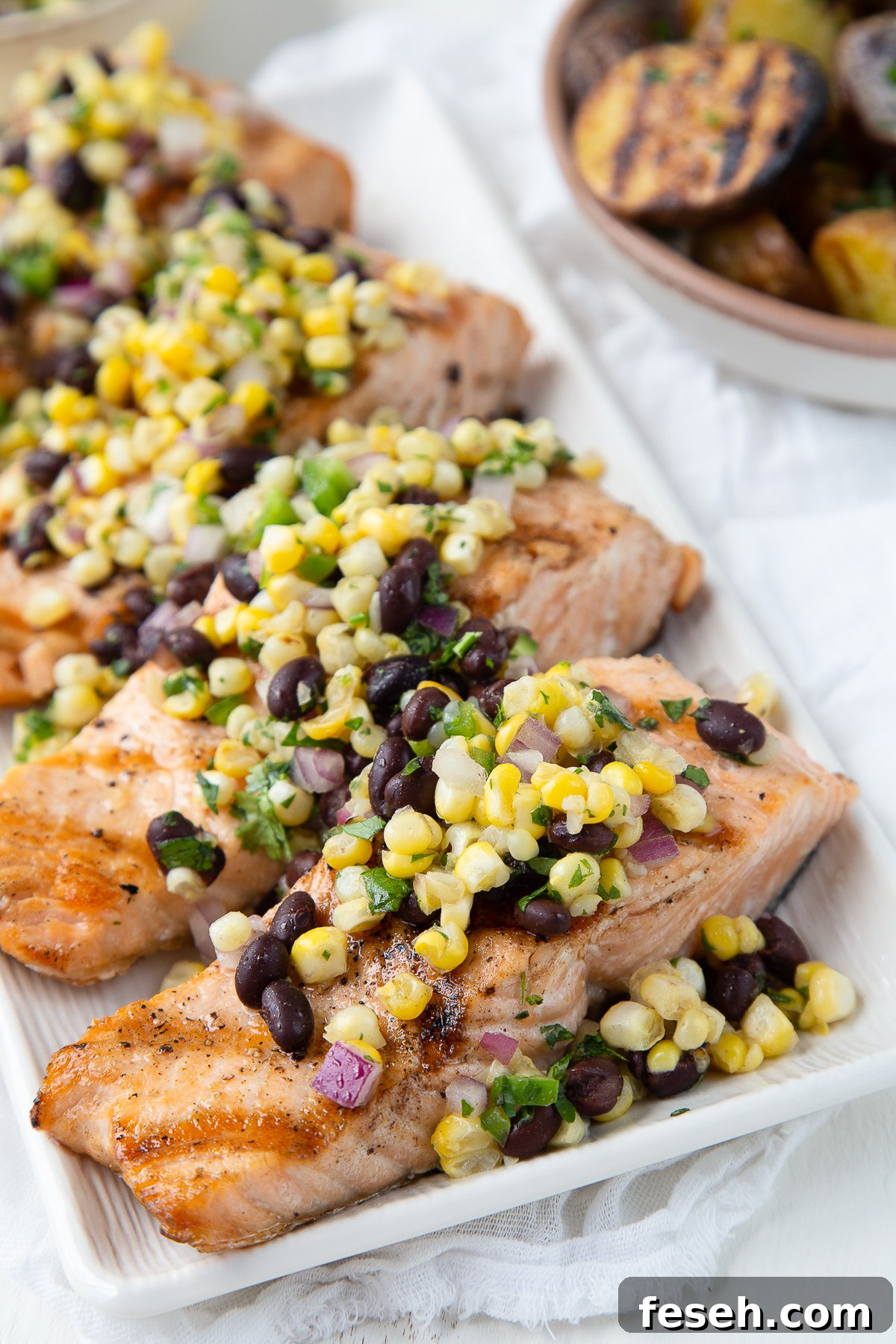 grilled salmon with corn salsa on a white platter