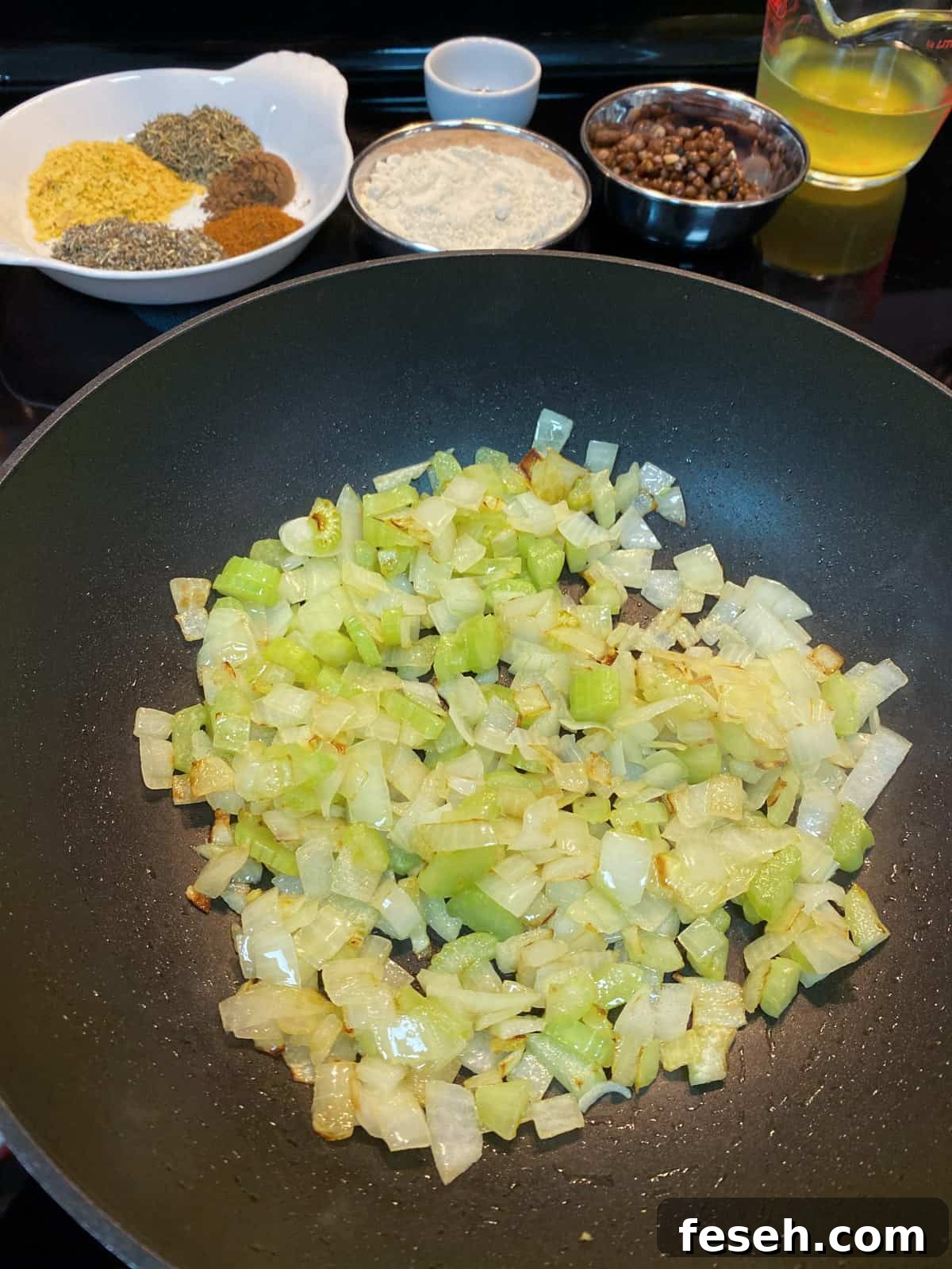 Photo of onion and celery frying in a pan.