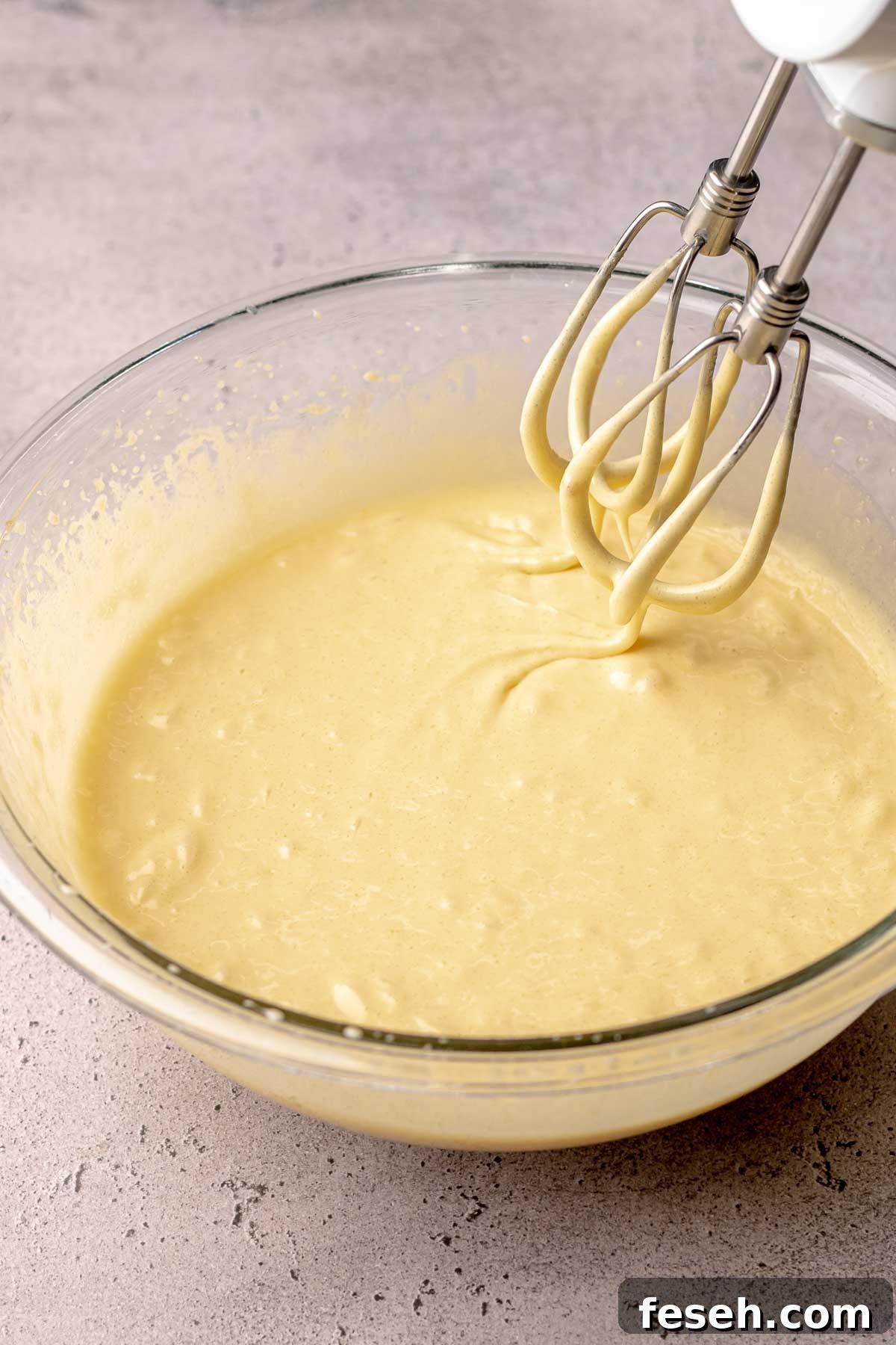 Brownie batter base in a bowl with beaters on the side.