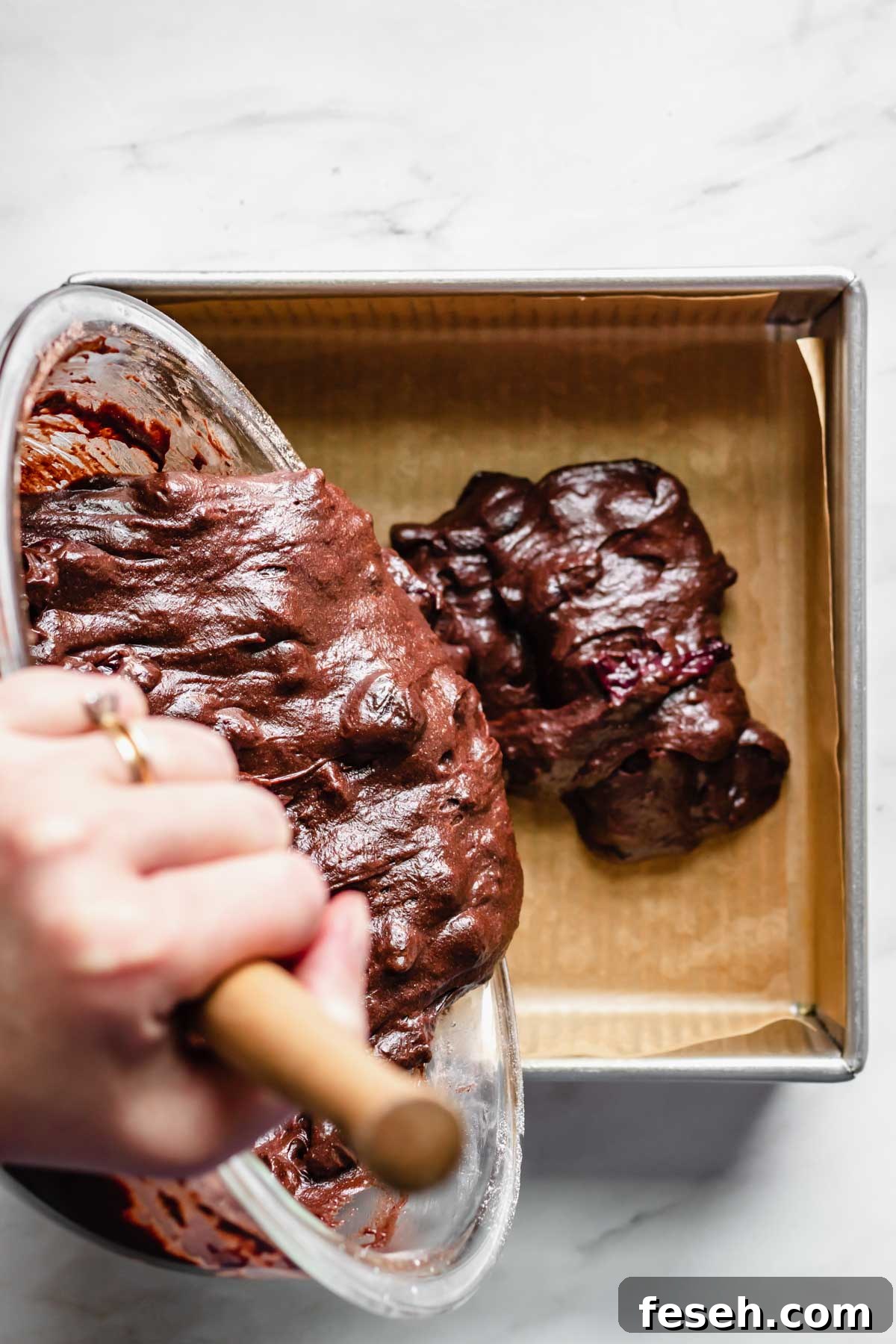Brownie batter poured into a square pan.