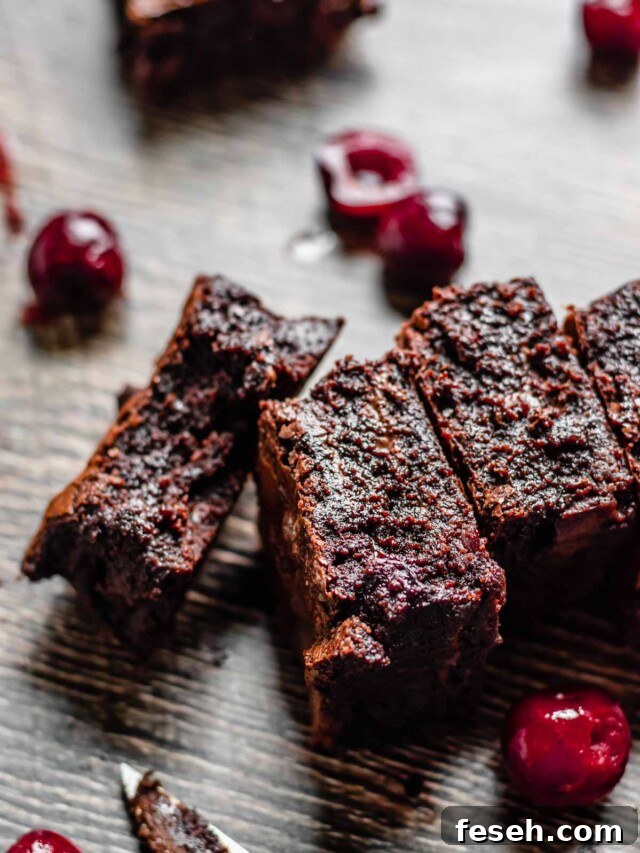 A line of brownies laying on their sides. One piece has a bite removed.