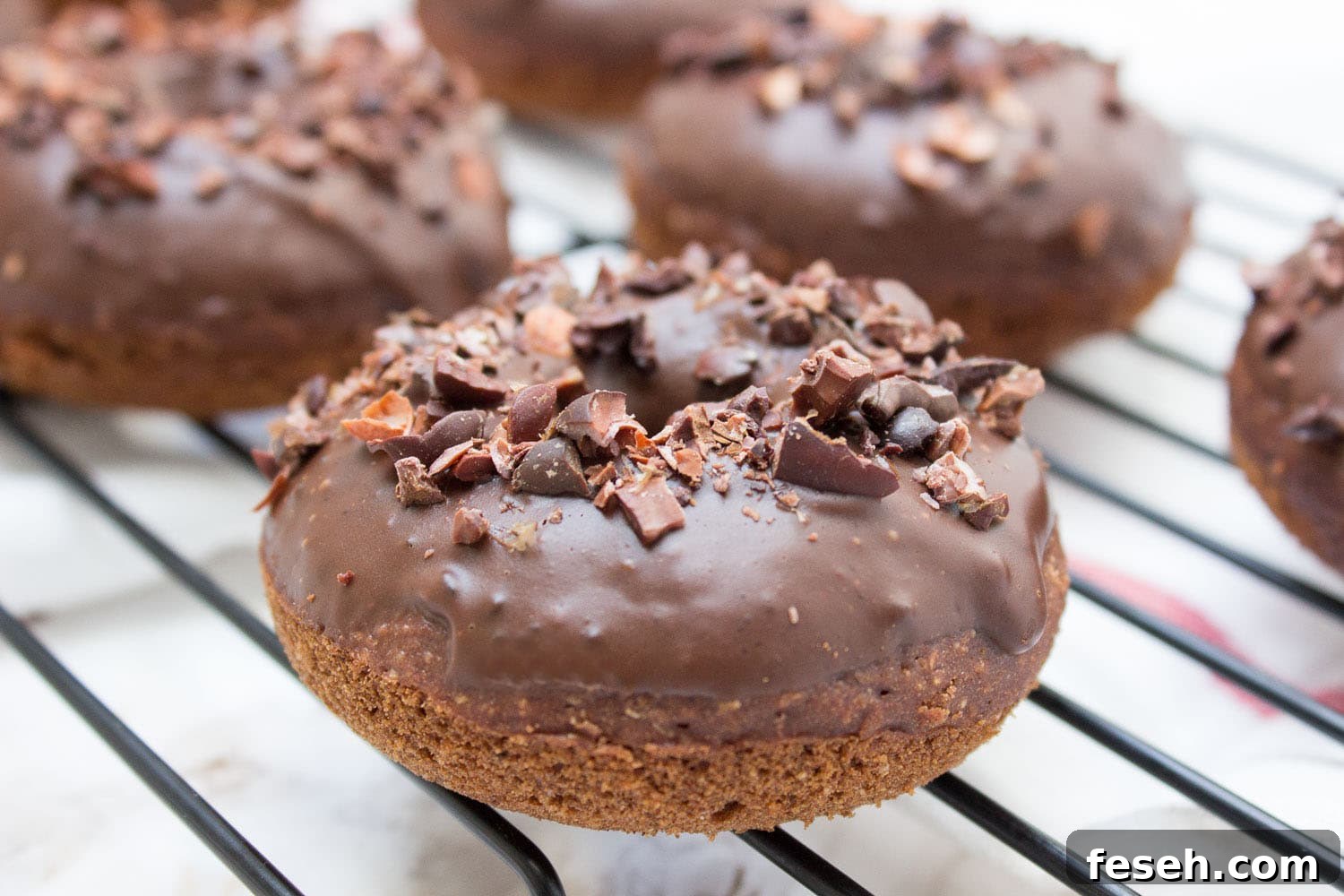 Baked whole wheat double chocolate banana donuts infused with cinnamon and topped with melted dark chocolate. These are made with all healthy ingredients, nutritious and contains no refined sugars!