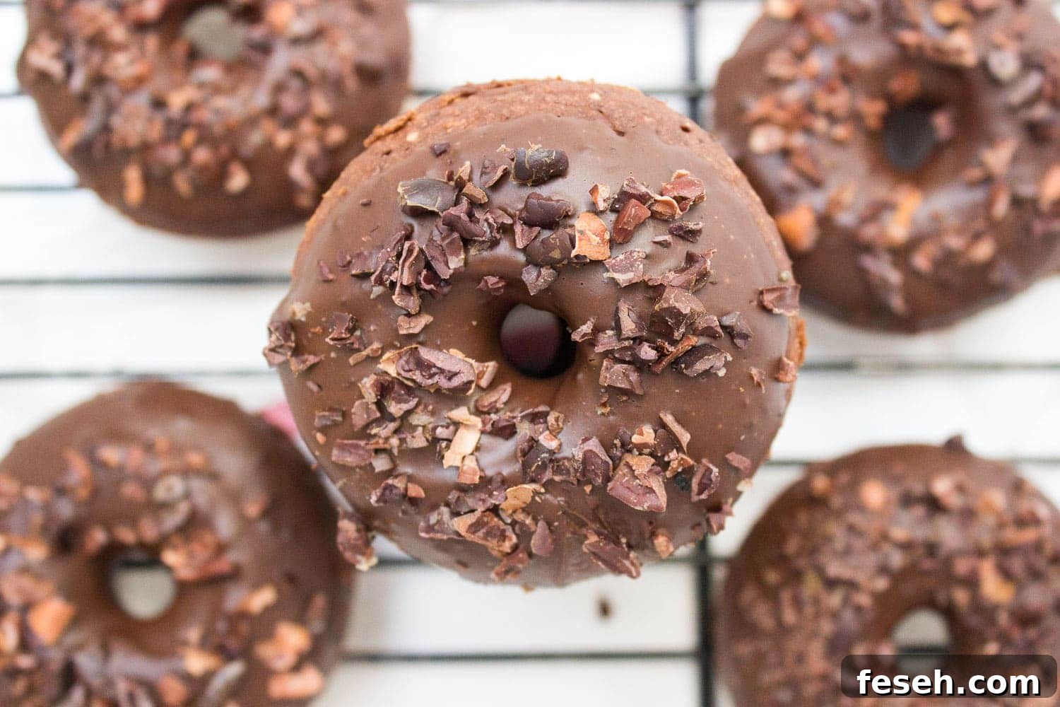 Baked whole wheat double chocolate banana donuts infused with cinnamon and topped with melted dark chocolate. These are made with all healthy ingredients, nutritious and contains no refined sugars!