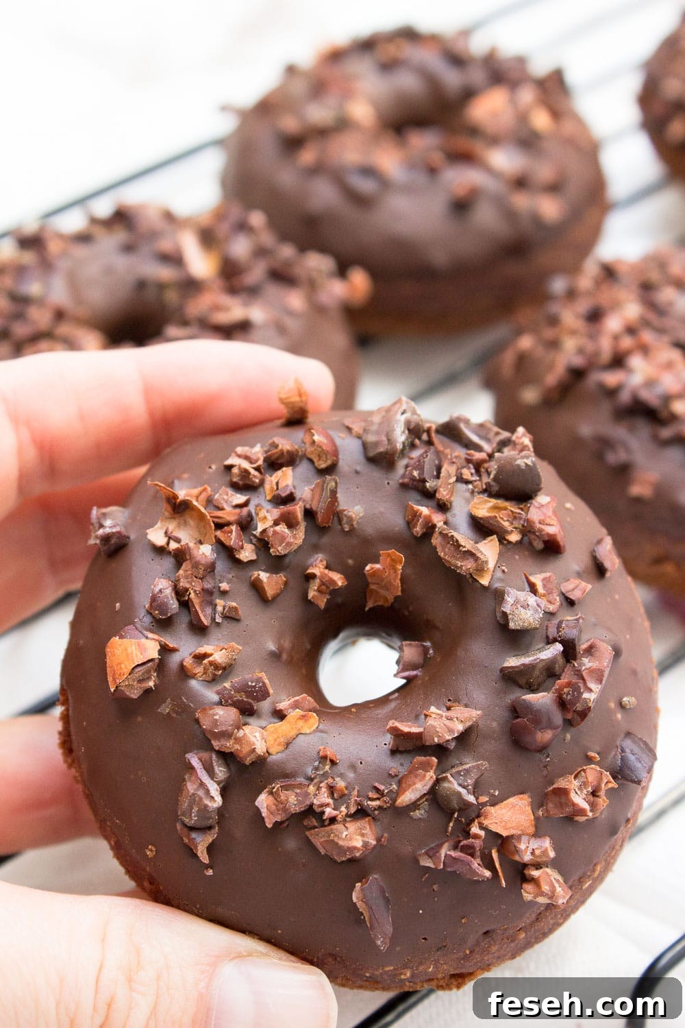 Baked whole wheat double chocolate banana donuts infused with cinnamon and topped with melted dark chocolate. These are made with all healthy ingredients, nutritious and contains no refined sugars!