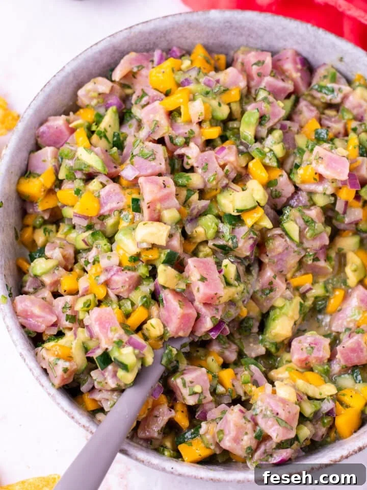 gray spoon scooping up fresh ahi tuna ceviche