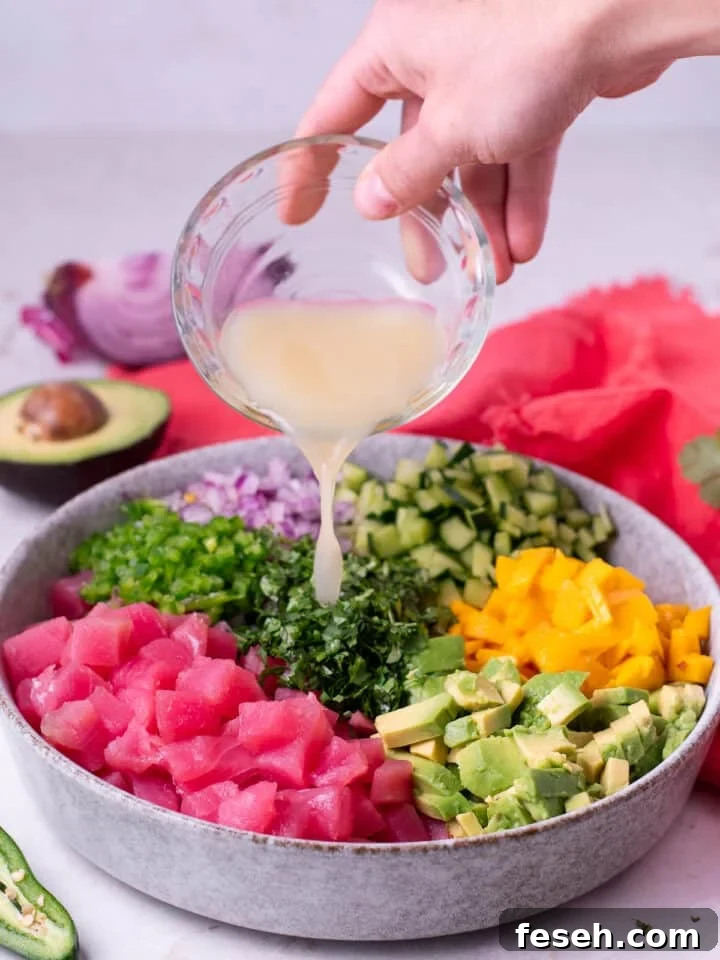 hand pouring a small bowl of lime juice into the ceviche