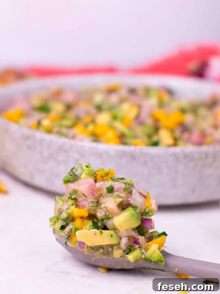 gray spoon with a large scoop of tuna ceviche on it