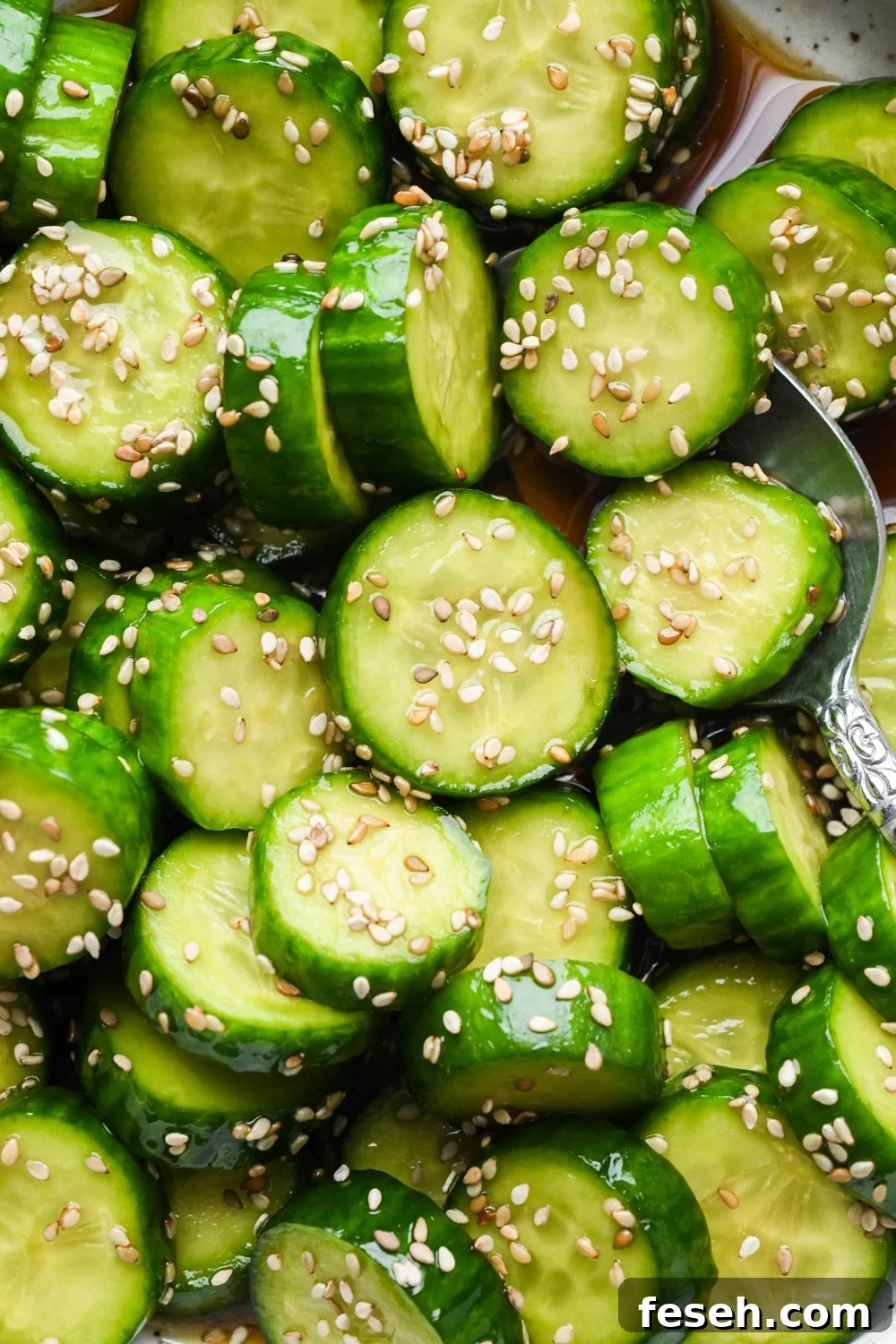 Close up shot of prepared cucumber sesame salad, topped with sesame seeds.