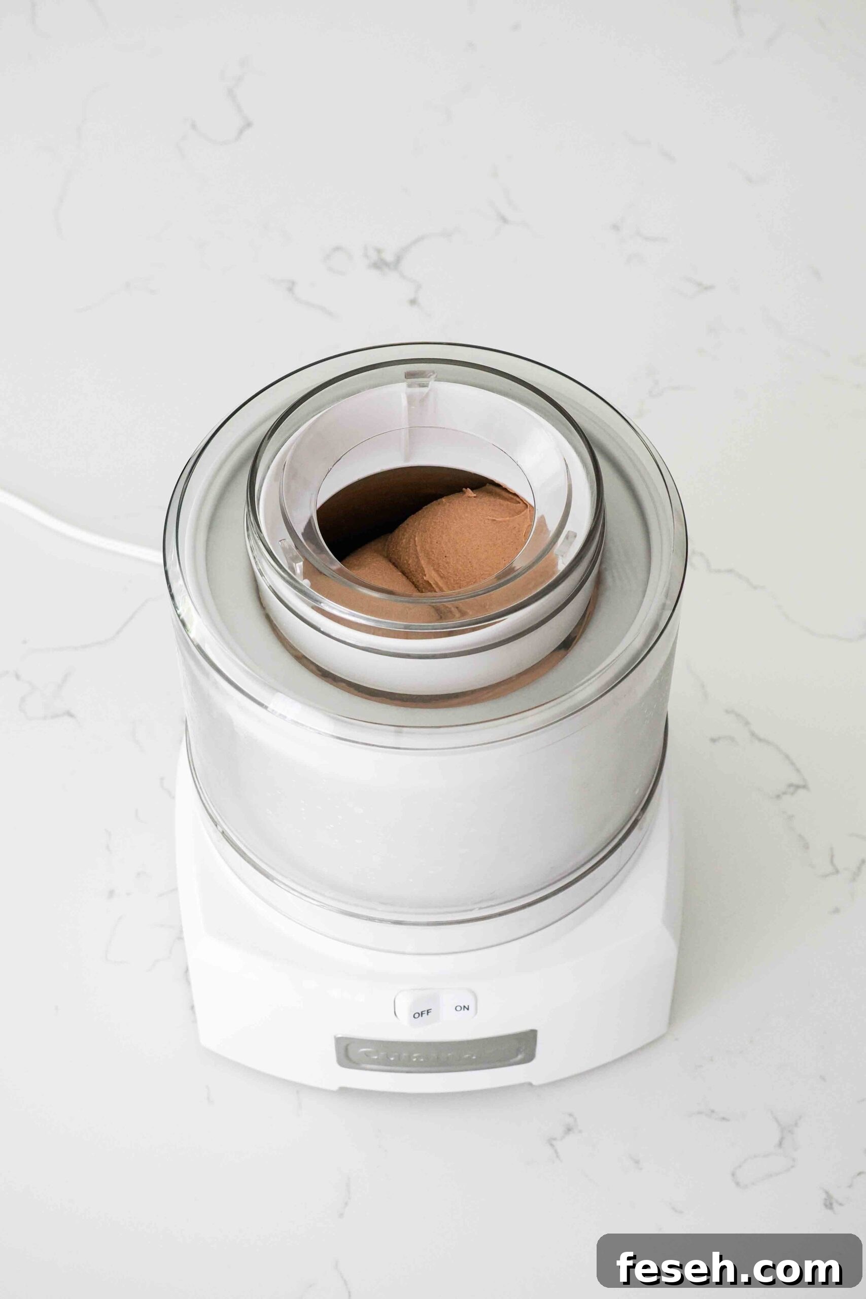Fully churned frozen custard forms rounded domes in an ice cream maker.