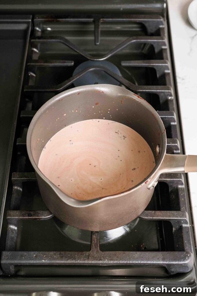 A pot of warmed chocolate milk and cream over the stove.