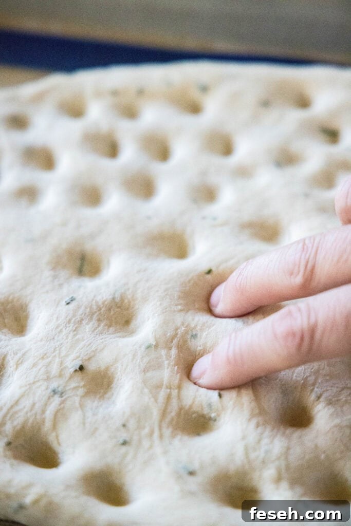 pressing dimples into focaccia bread