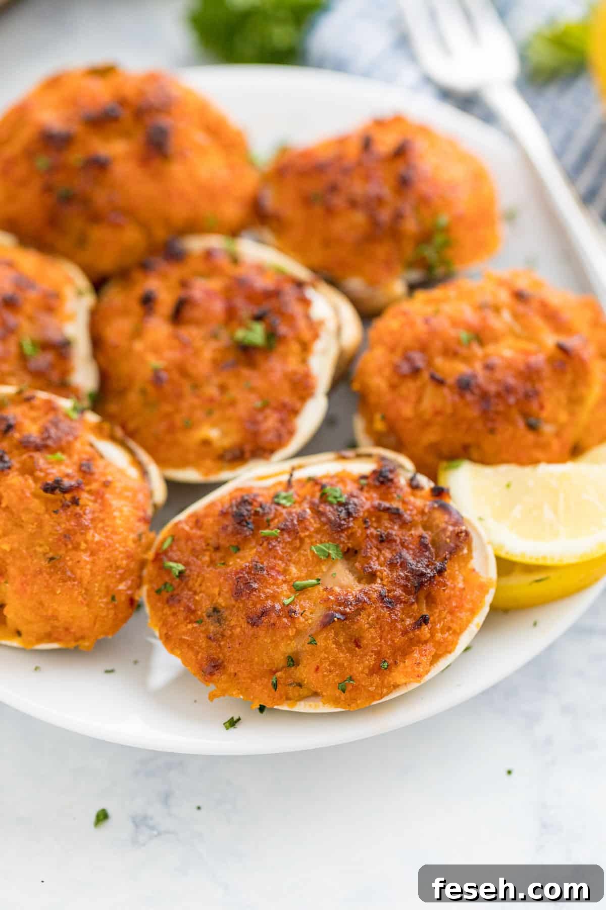 A close up image of baked clams on the side of a plate.
