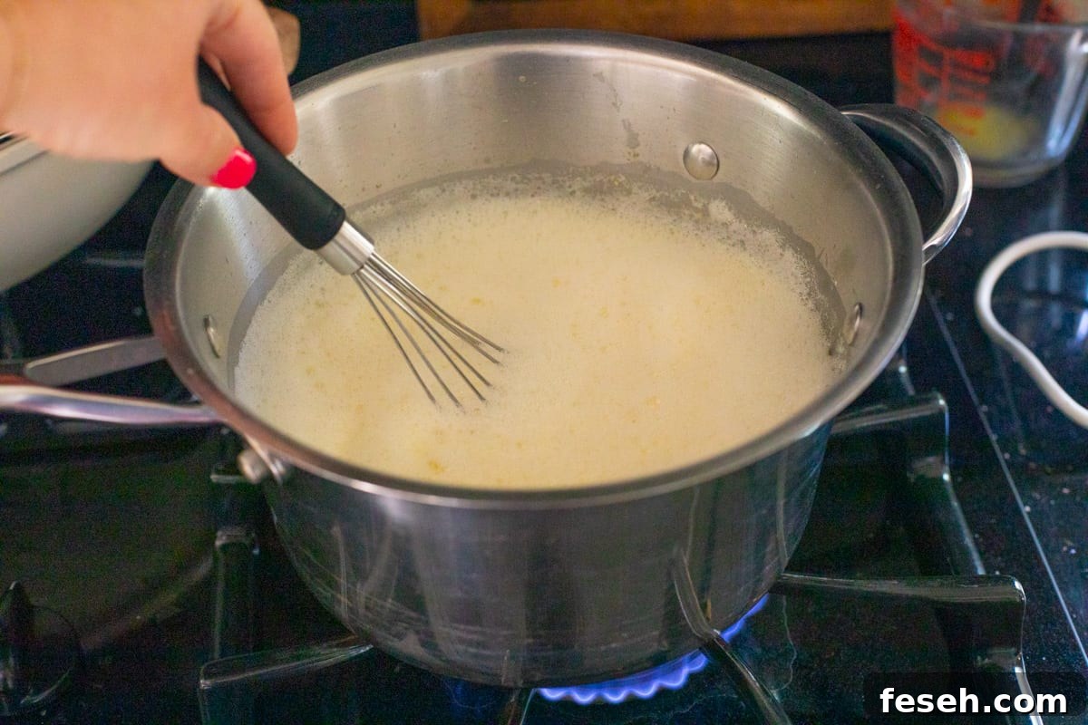 pot with a whisk stirring pastry cream mixture, set over a hot stove to cook.
