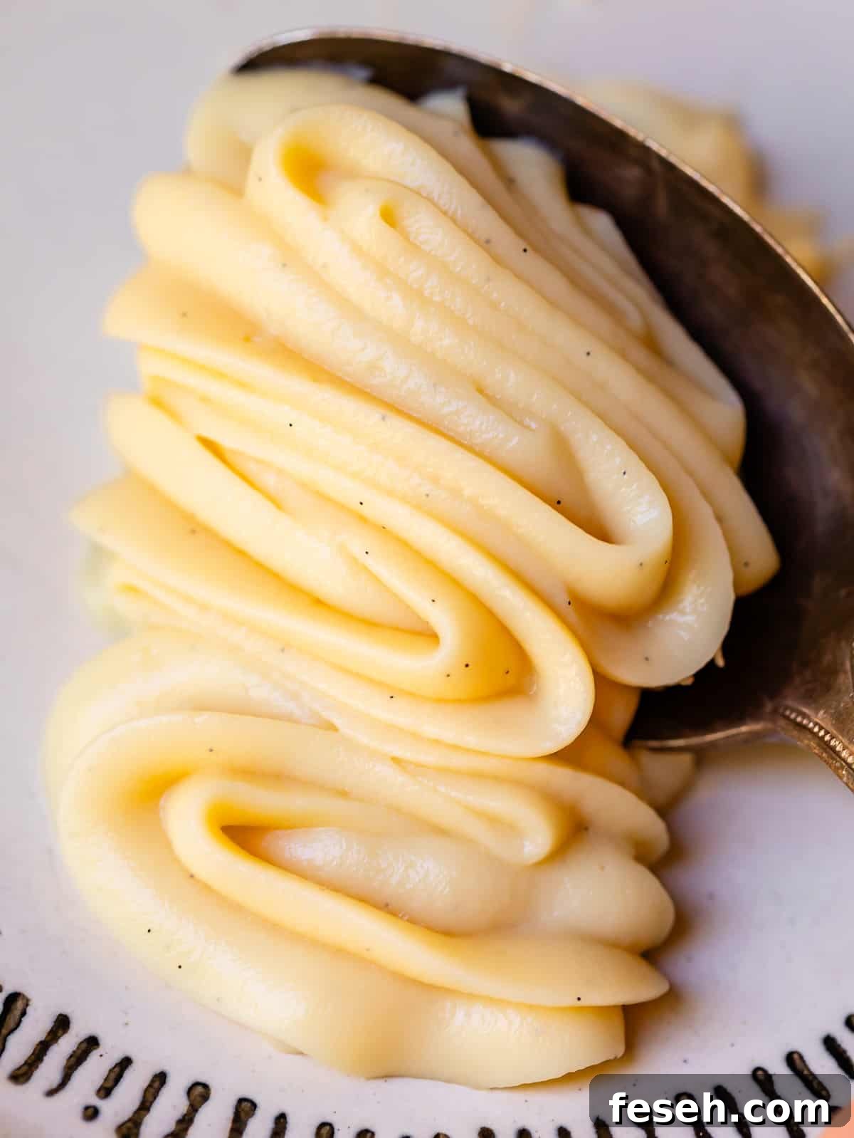 silver spoon scooping up some of the piped vanilla pastry cream and the shape holding.