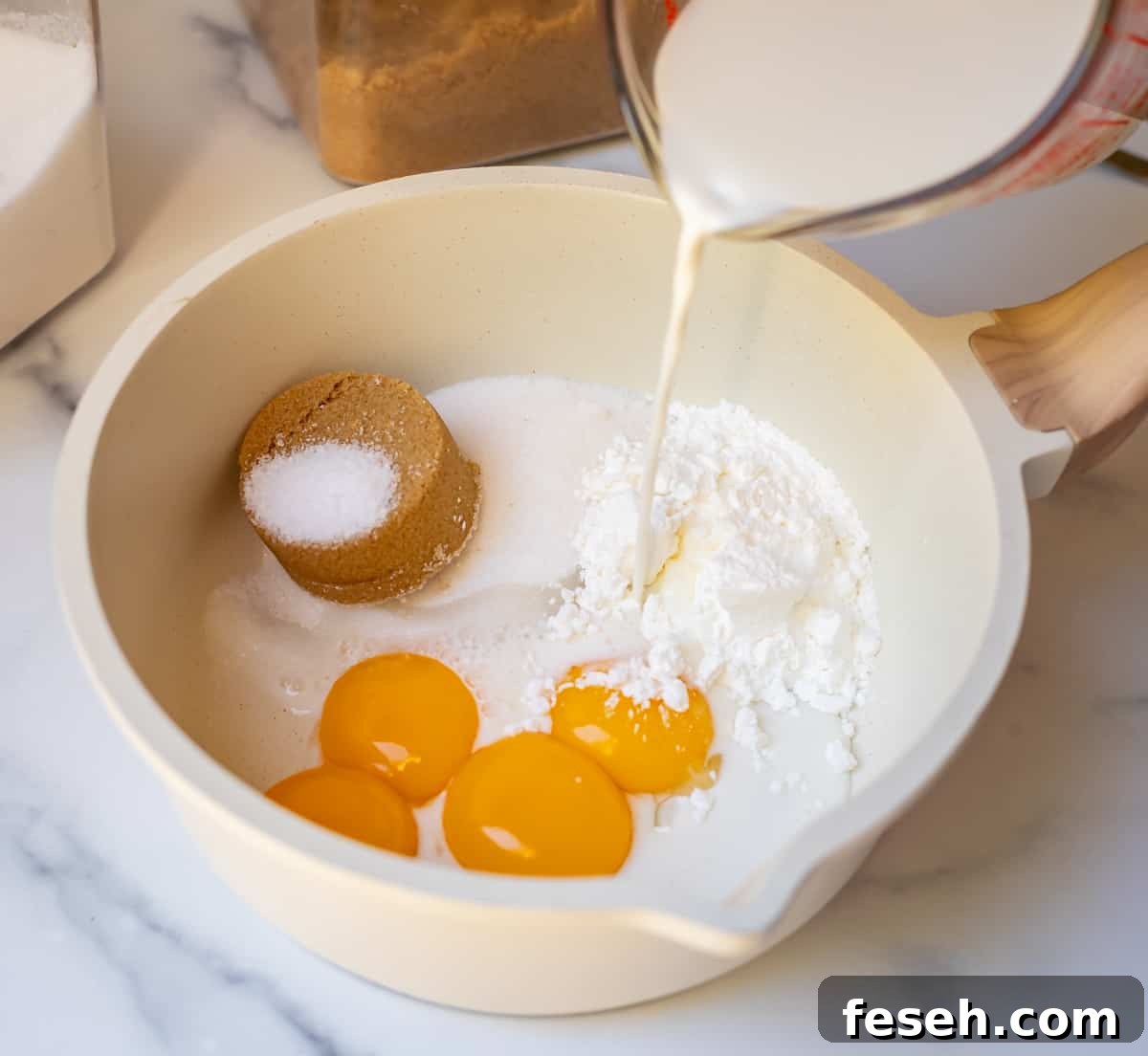 milk being poured into a bowl that has sugar and eggs in it for pastry cream.