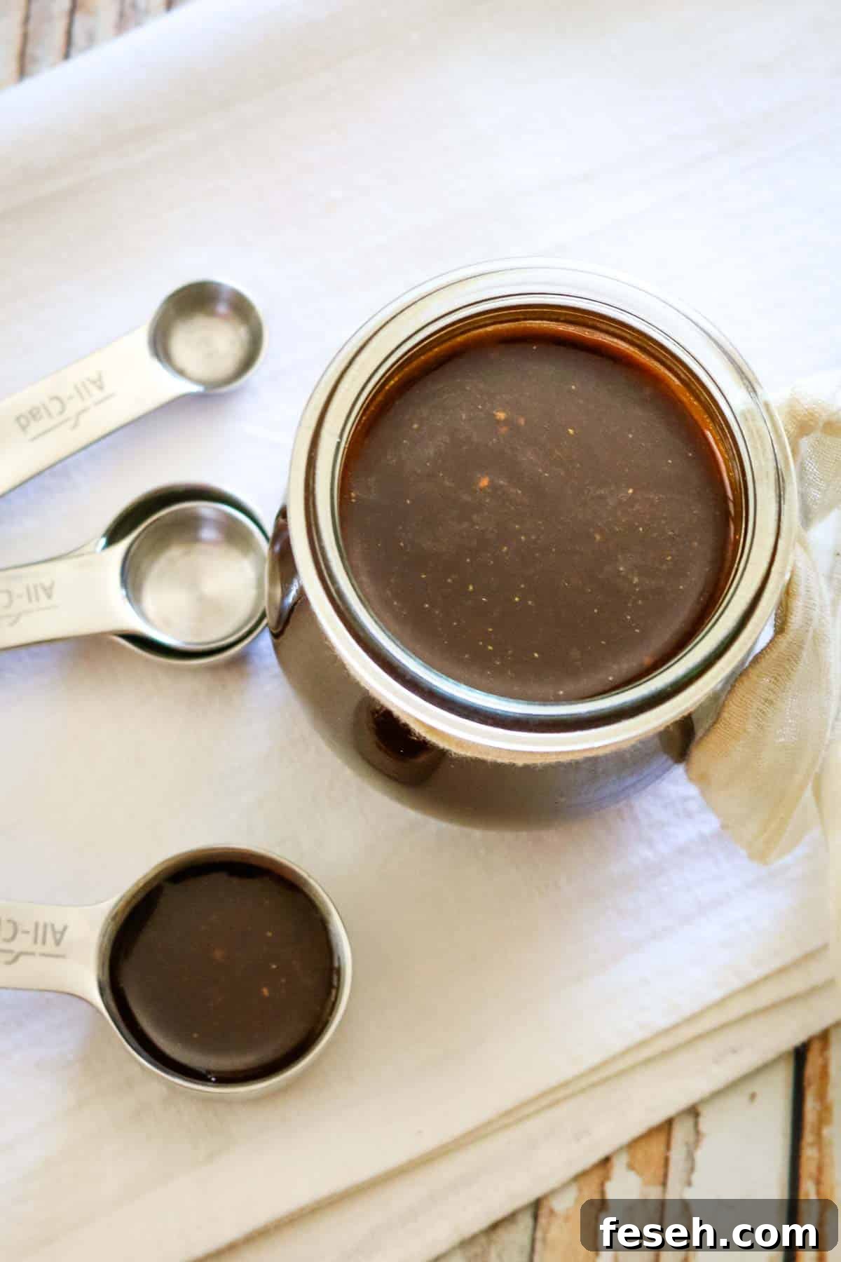 measuring spoons and small jar of dark sauce
