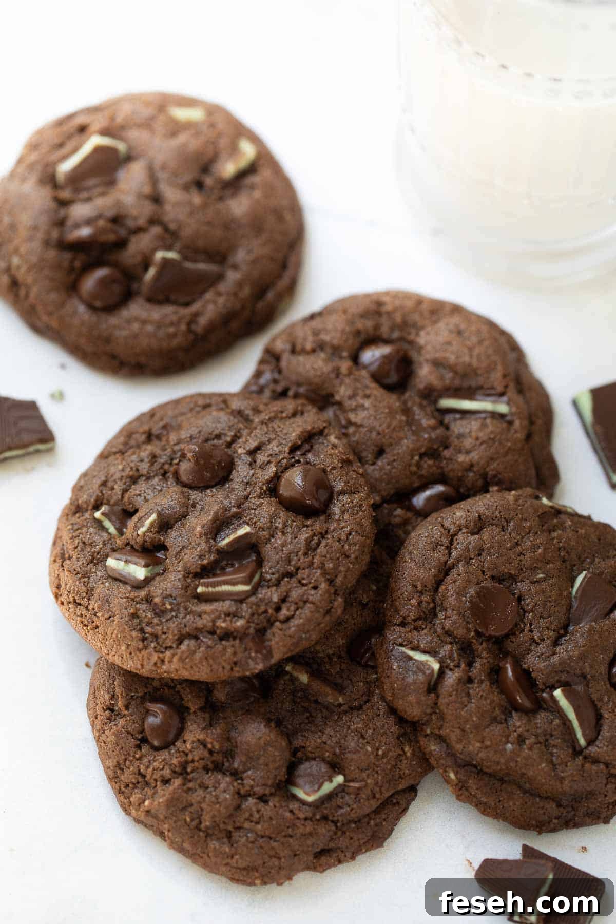 close up shot of gluten free chocolate mint cookies on white background with milk