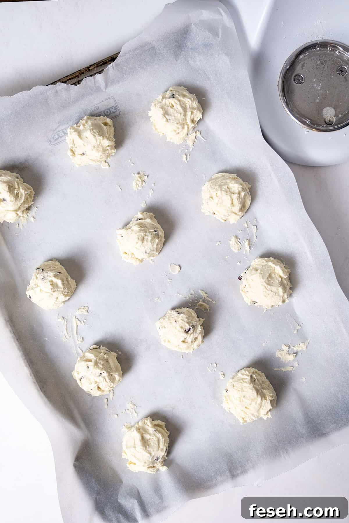 Cookie dough on a parchment paper lined baking tray. 