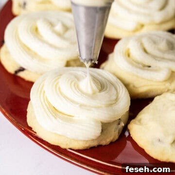 Cookies being frosted with a piping bag.