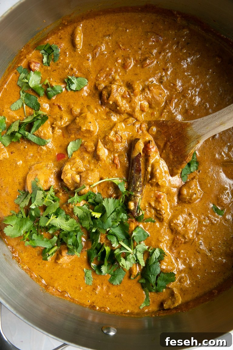 Large pot filled with Indian Butter Chicken garnished with fresh cilantro ready to be served.