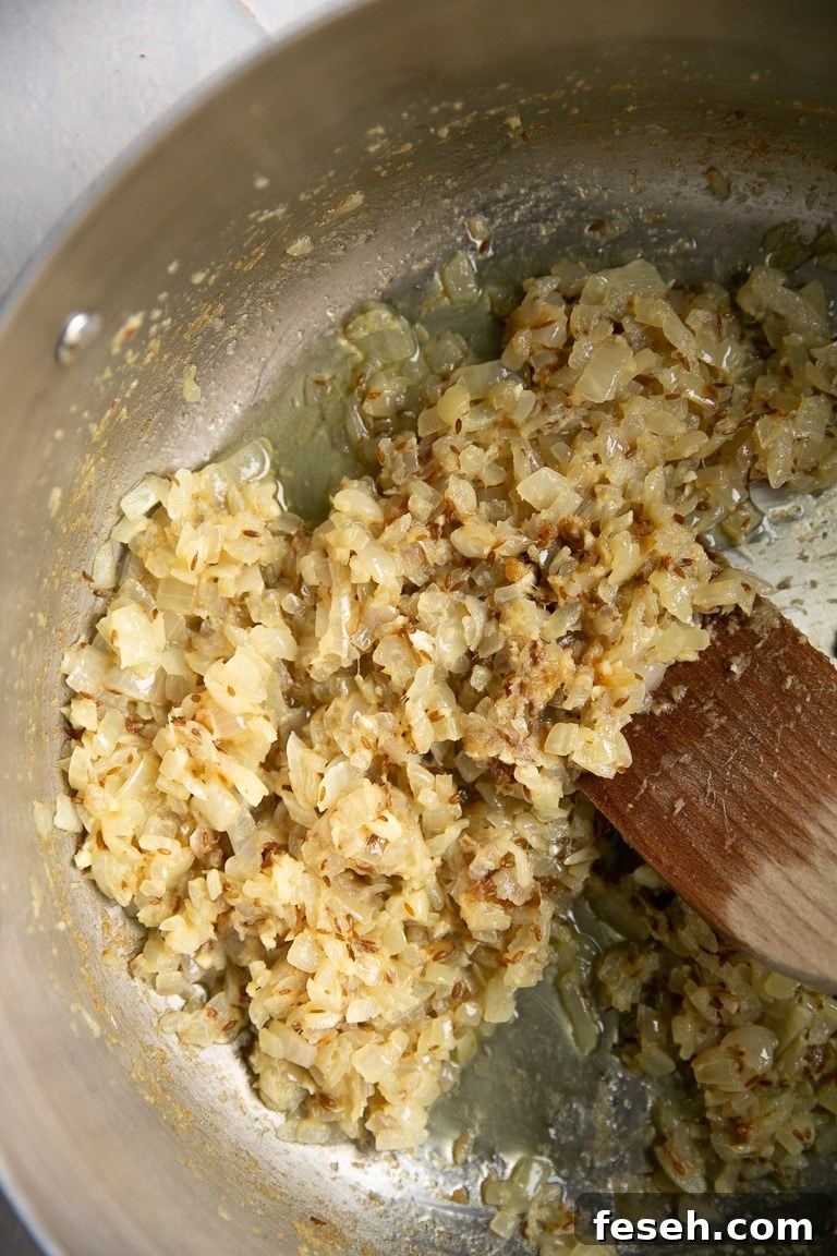 onions, butter, garlic, ginger, and cumin seeds cooking in the pot for murgh makhani.