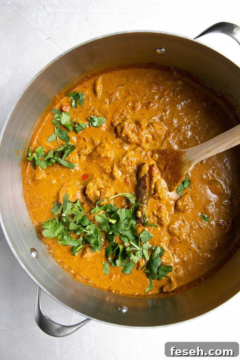 Overhead image of a large pot filled with creamy butter chicken garnished with cilantro ready to be served.