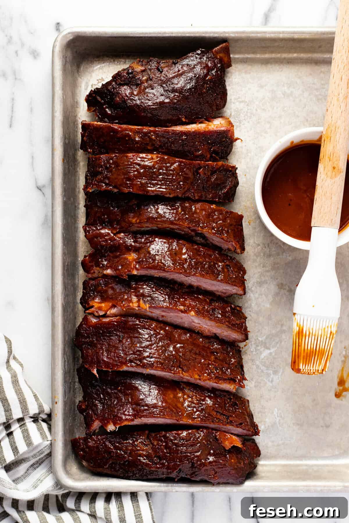 Small sheet pan with smoked ribs and BBQ sauce on it.