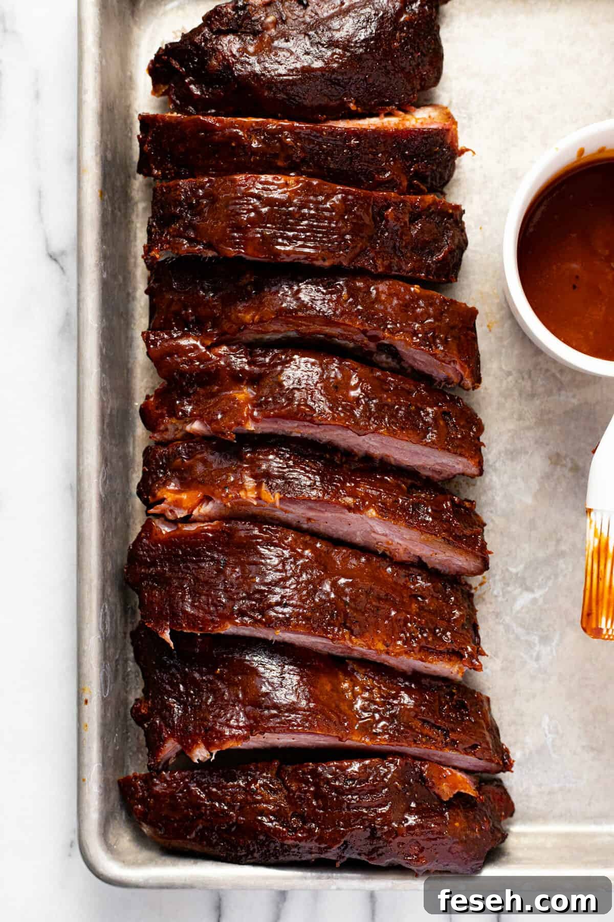Overhead shot of a sheet pan with sliced baby back ribs on it.