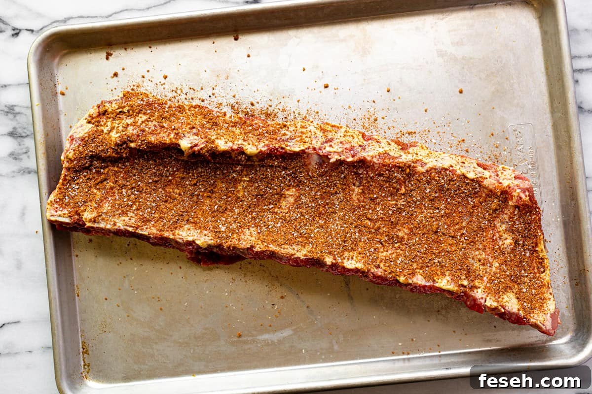Sheet pan with seasoned baby back ribs.